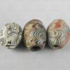 Three ancient folded glass beads 22SH7. Found in Afghanistan. Islamic period, circa 9th-12th century.